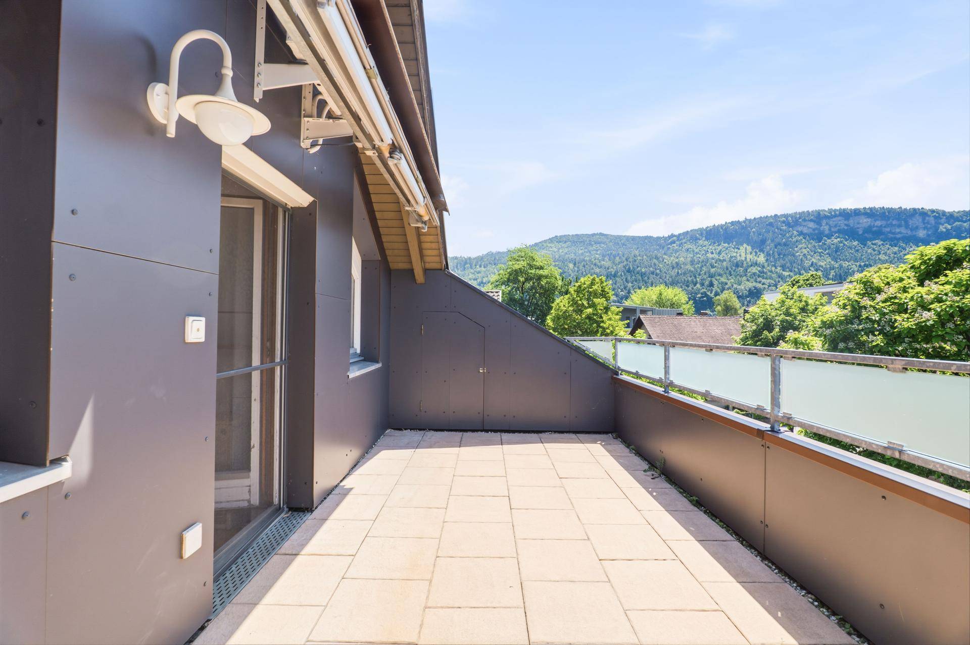 Sonnige Dachterrasse mit weitem Blick auf die umliegende Hügellandschaft.