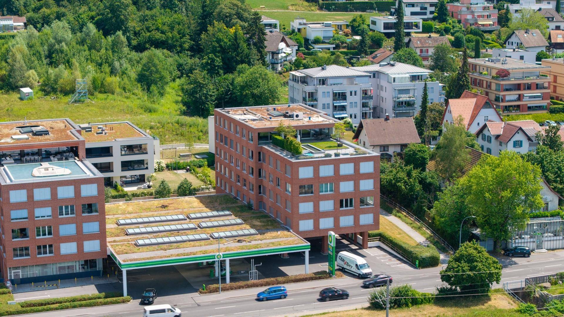 Detailaufnahme der modernen Gebäude mit begrünten Dächern und der umliegenden Infrastruktur.