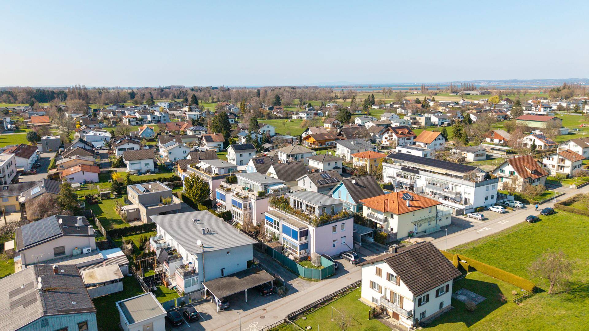 Weitläufige Luftaufnahme der Wohnsiedlung mit viel Grün und Fernblick.