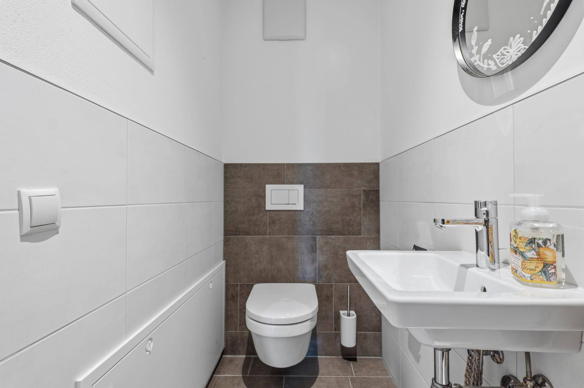 Modernes Gäste-WC mit Wand-WC und kleinem Waschbecken.