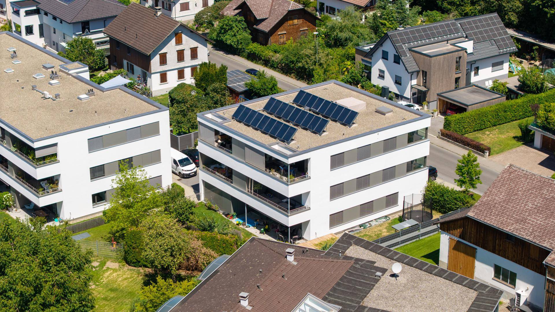 Luftaufnahme eines modernen Wohngebäudes mit Flachdach und Solaranlage.
