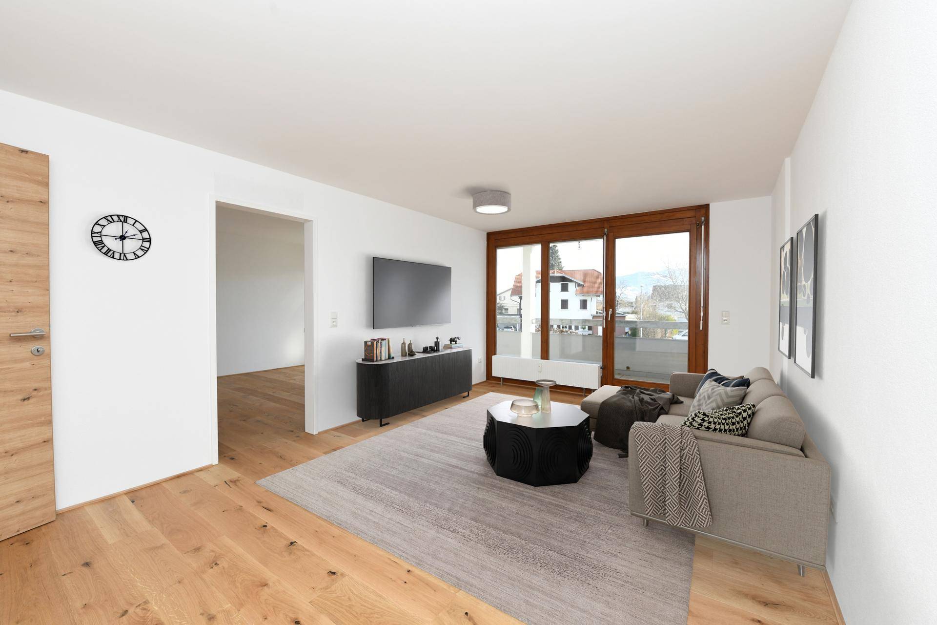 Virtuell möbliertes Wohnzimmer mit modernem Sofa, Teppich und Zugang zum Balkon.