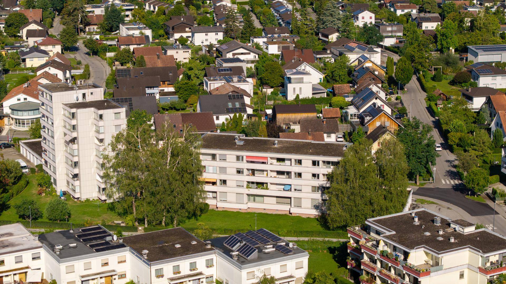 Luftaufnahme einer Wohnsiedlung mit vielen Häusern und Grünflächen.