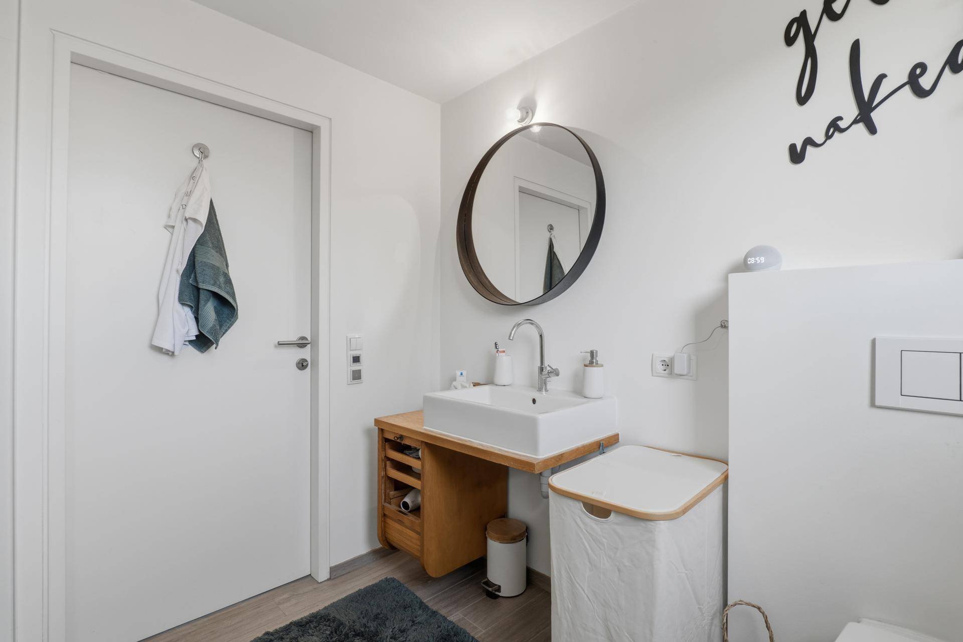 Modernes Badezimmer mit Einzelwaschbecken und Holzunterschrank.