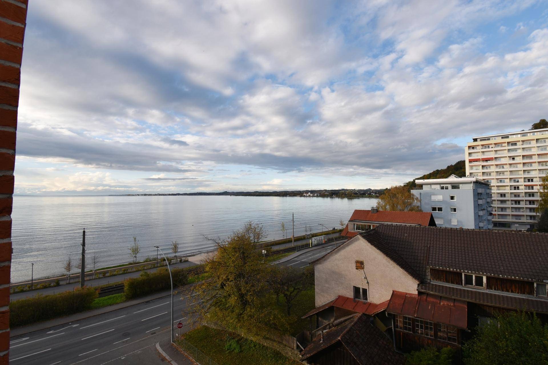 Weitläufiger Blick auf den See, die Uferpromenade und die umliegende Bebauung.