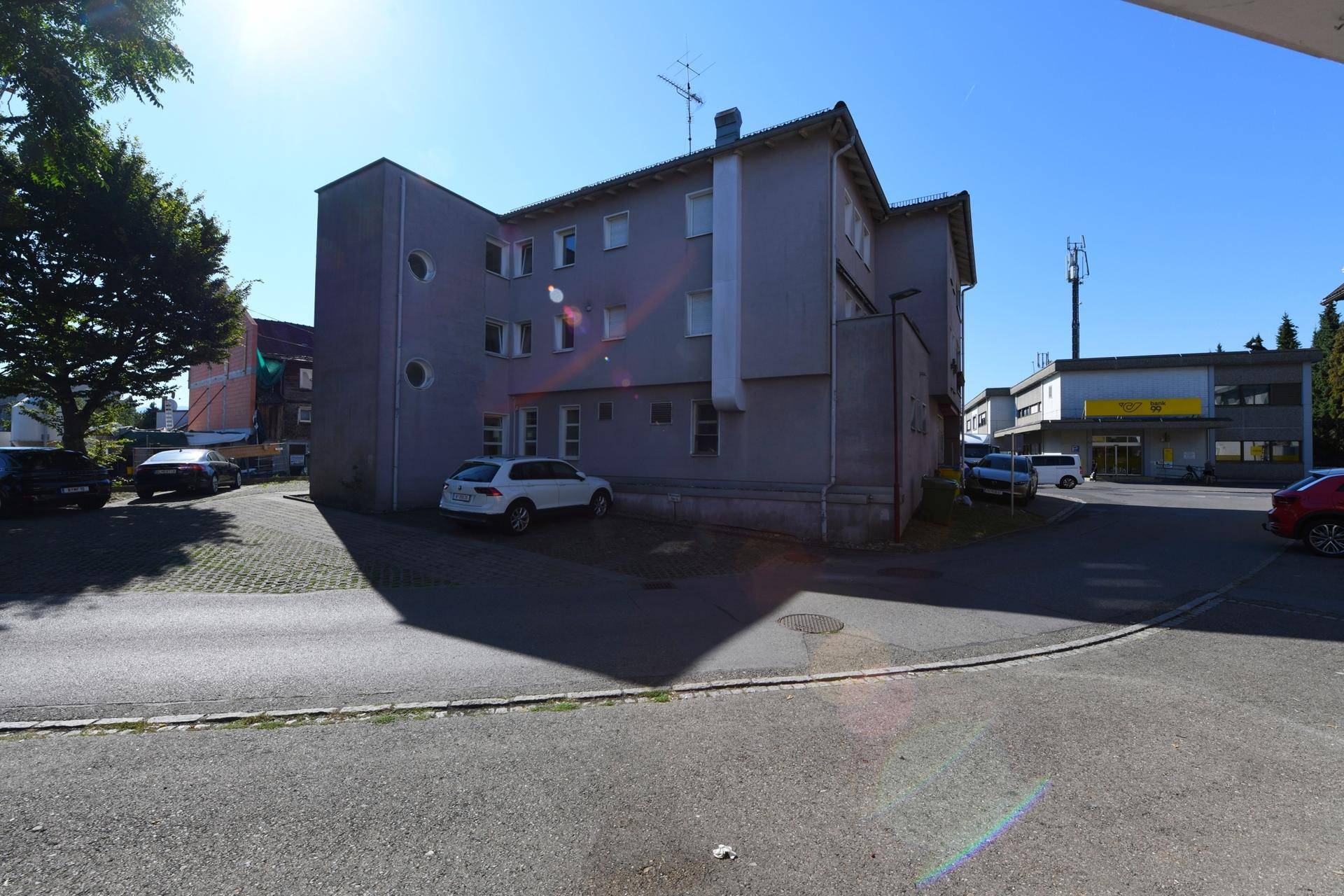 Seitenansicht des Mehrfamilienhauses mit Parkplätzen im Freien.