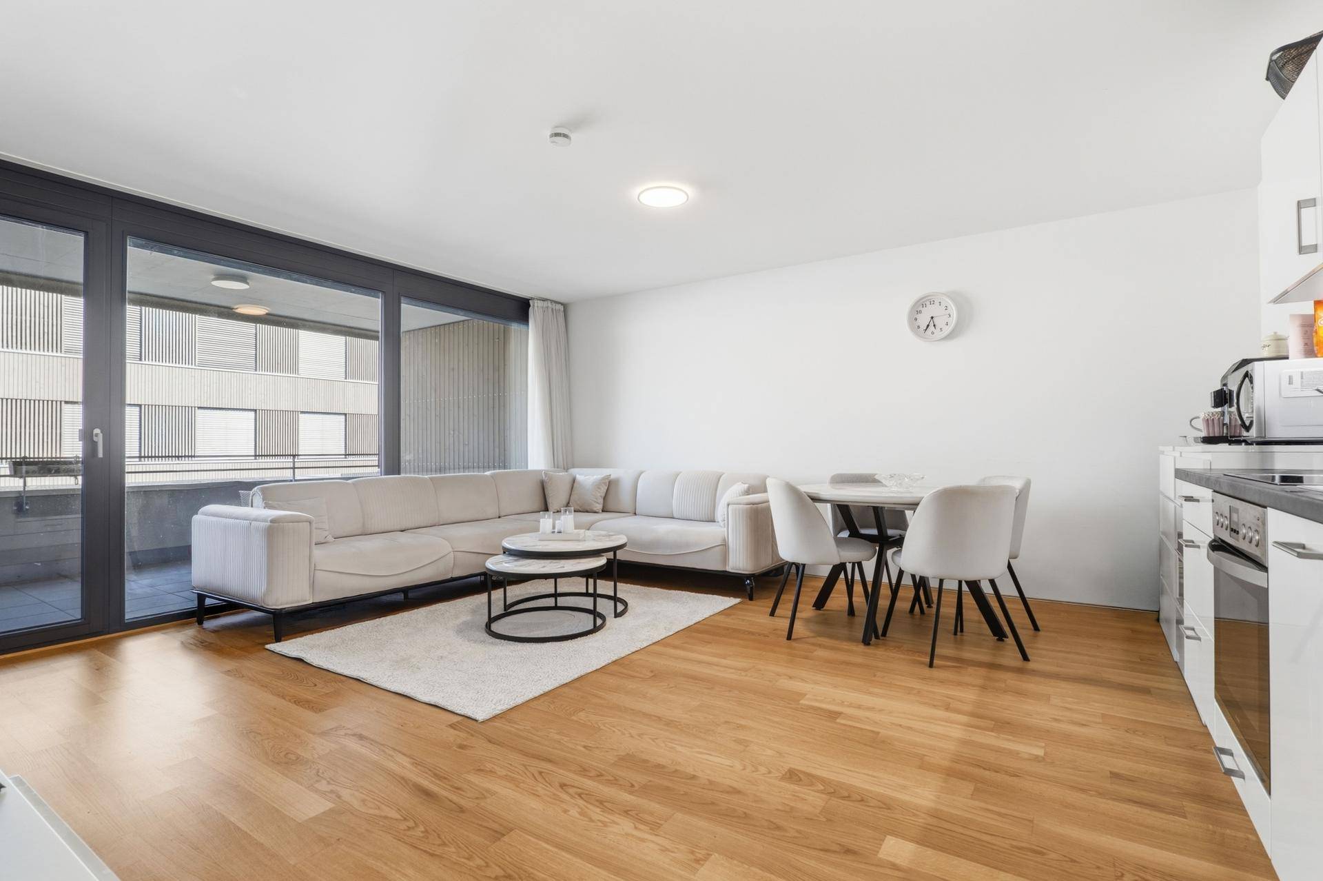 Heller Wohnbereich mit großem Sofa, Esstisch und Zugang zur Außenterrasse.