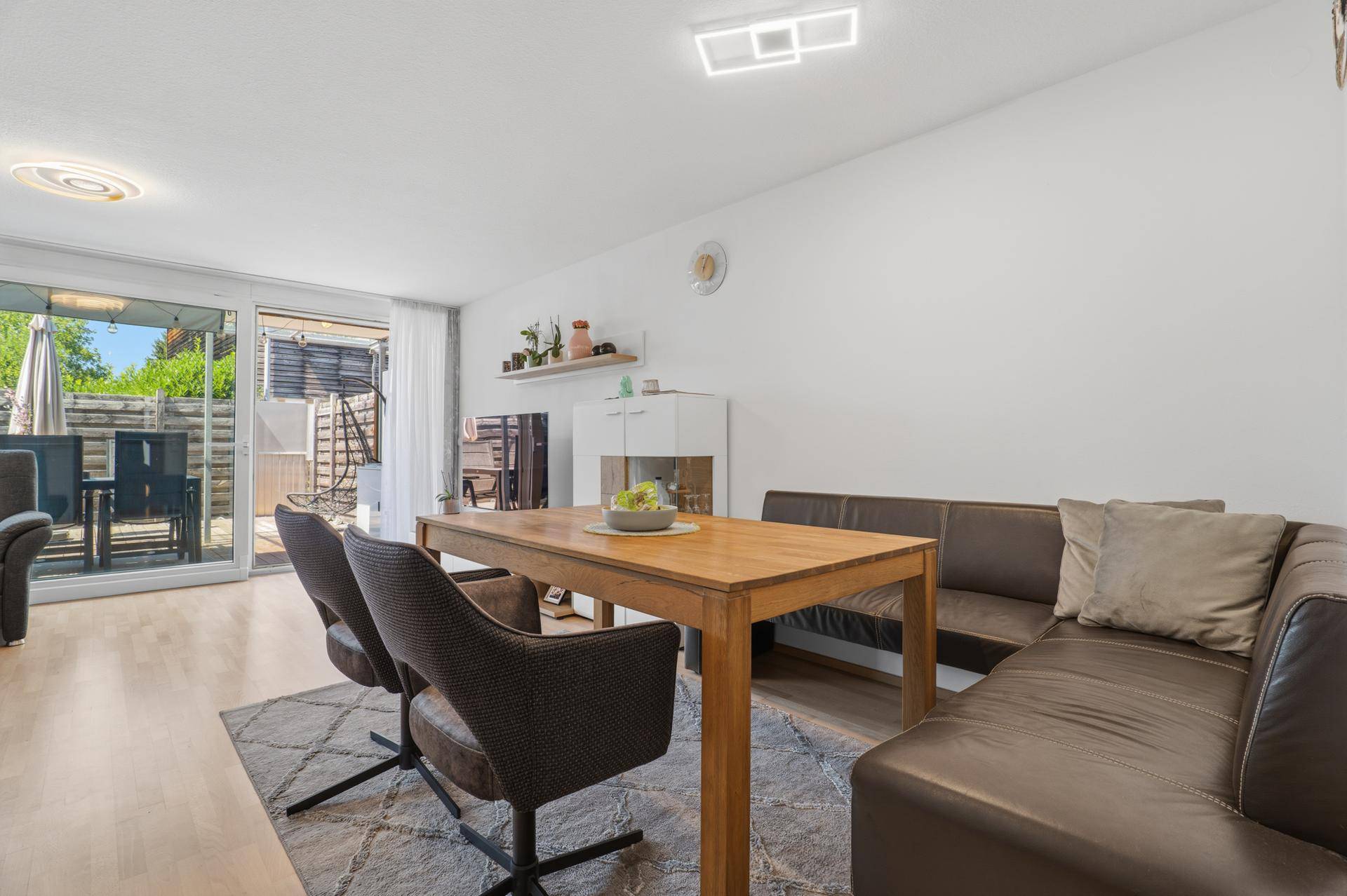 Essbereich mit Holztisch, bequemer Sitzbank und direktem Zugang zur sonnigen Terrasse.