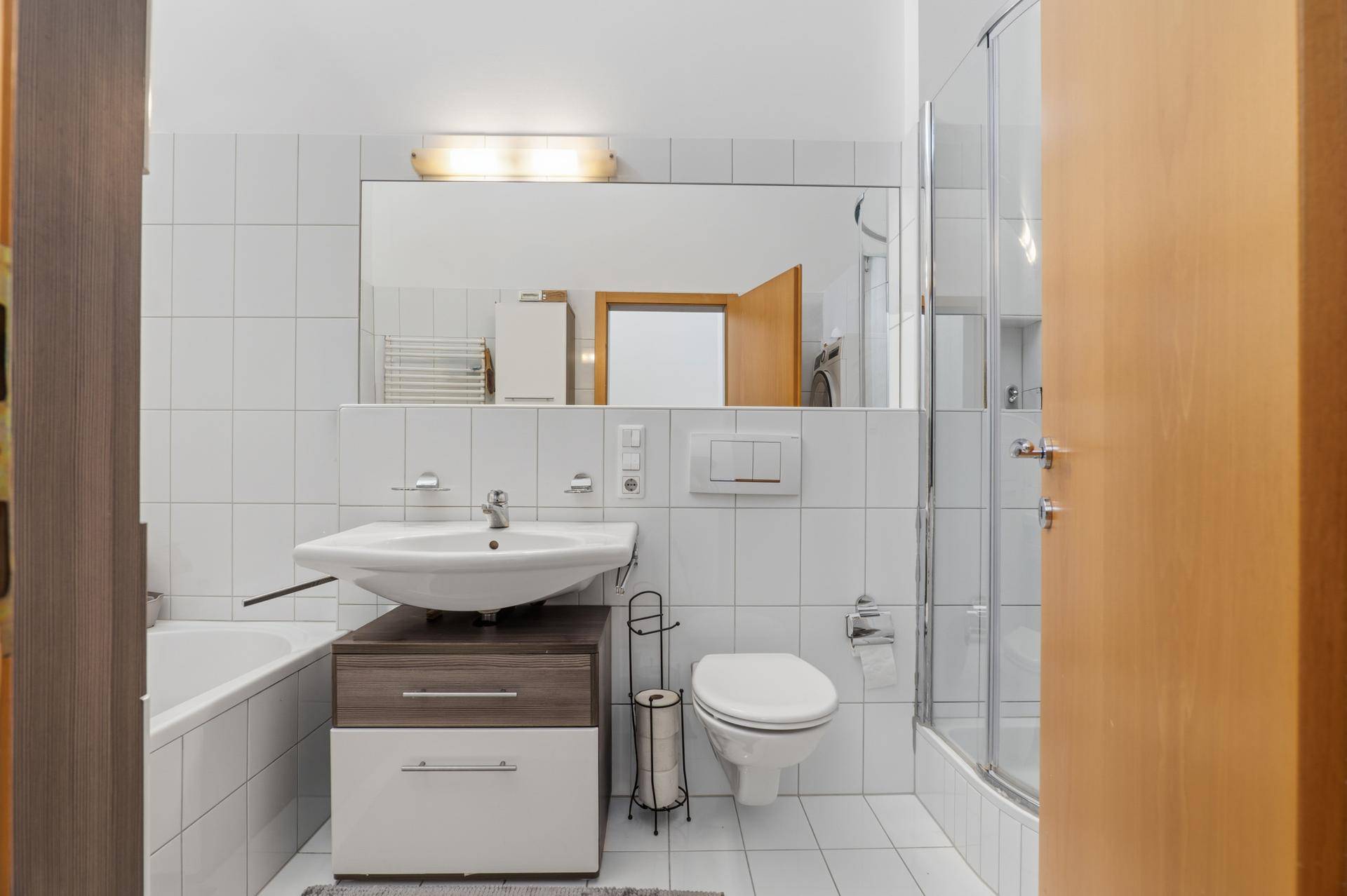 Modernes Badezimmer mit Badewanne, Dusche, Waschbecken und WC.