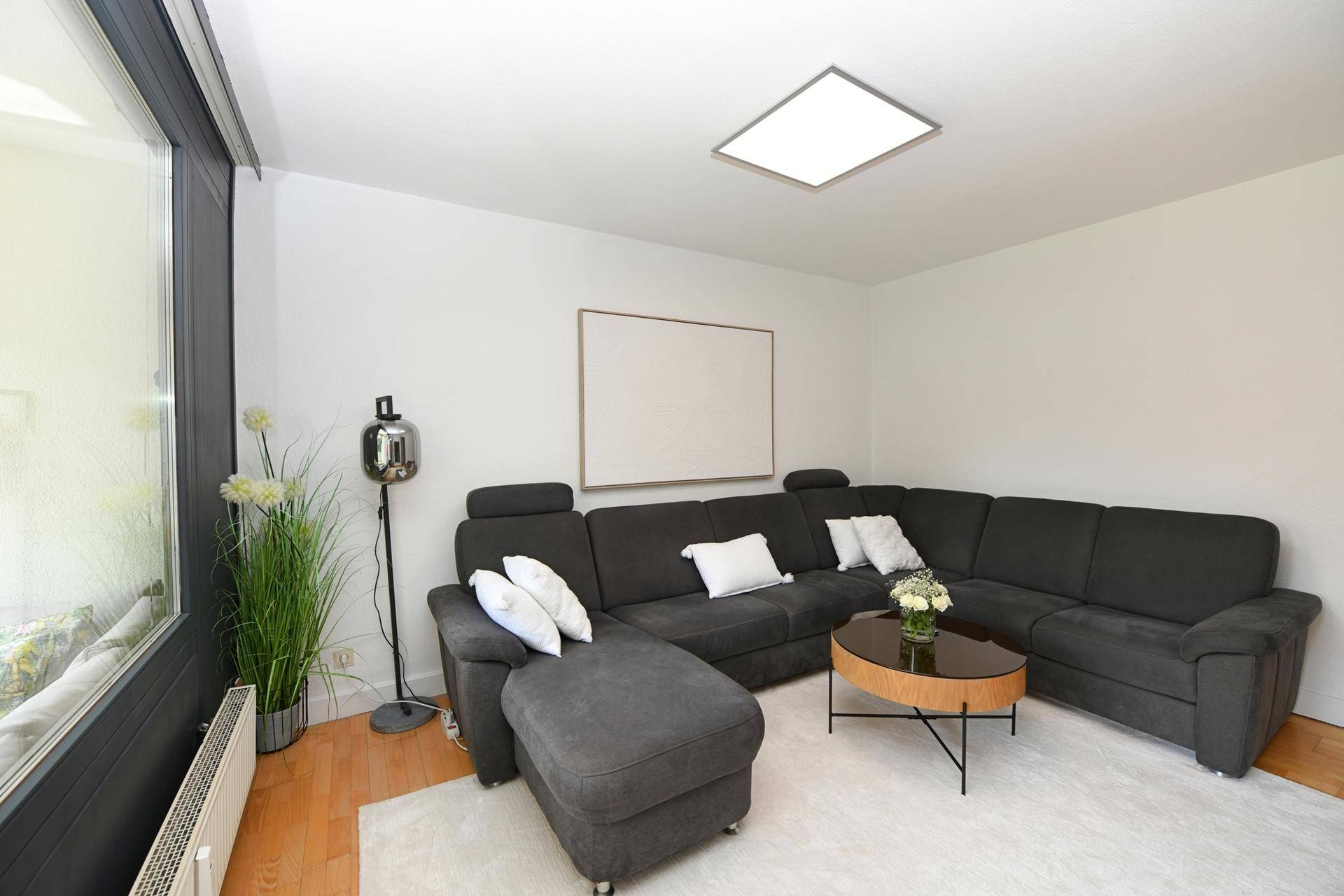 Geräumiges Wohnzimmer mit bequemer Eckcouch, modernem Couchtisch und viel Tageslicht.