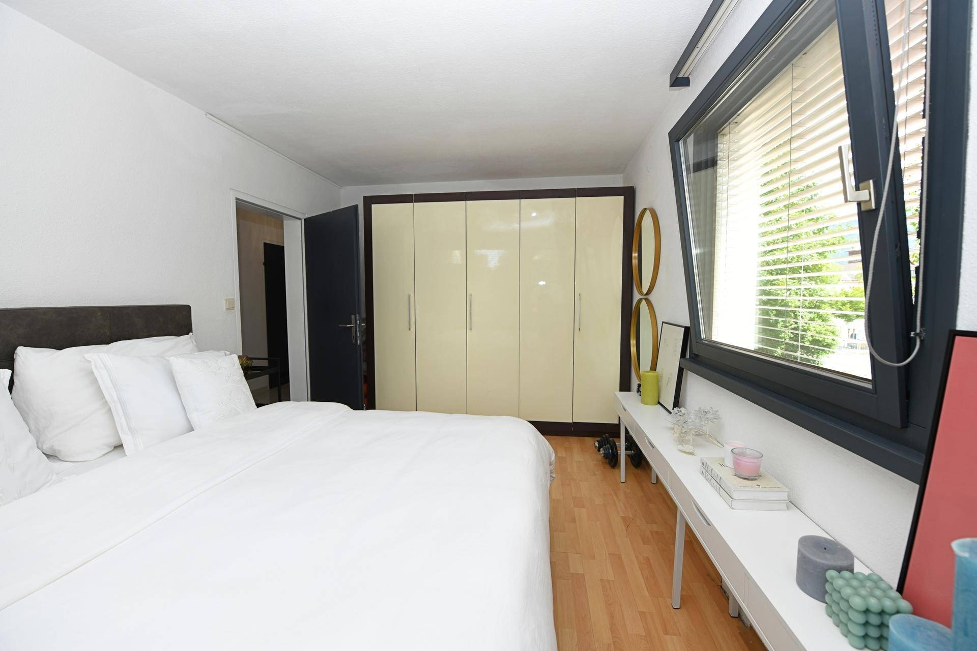 Geräumiges Schlafzimmer mit Doppelbett, Holzboden und großem Kleiderschrank.