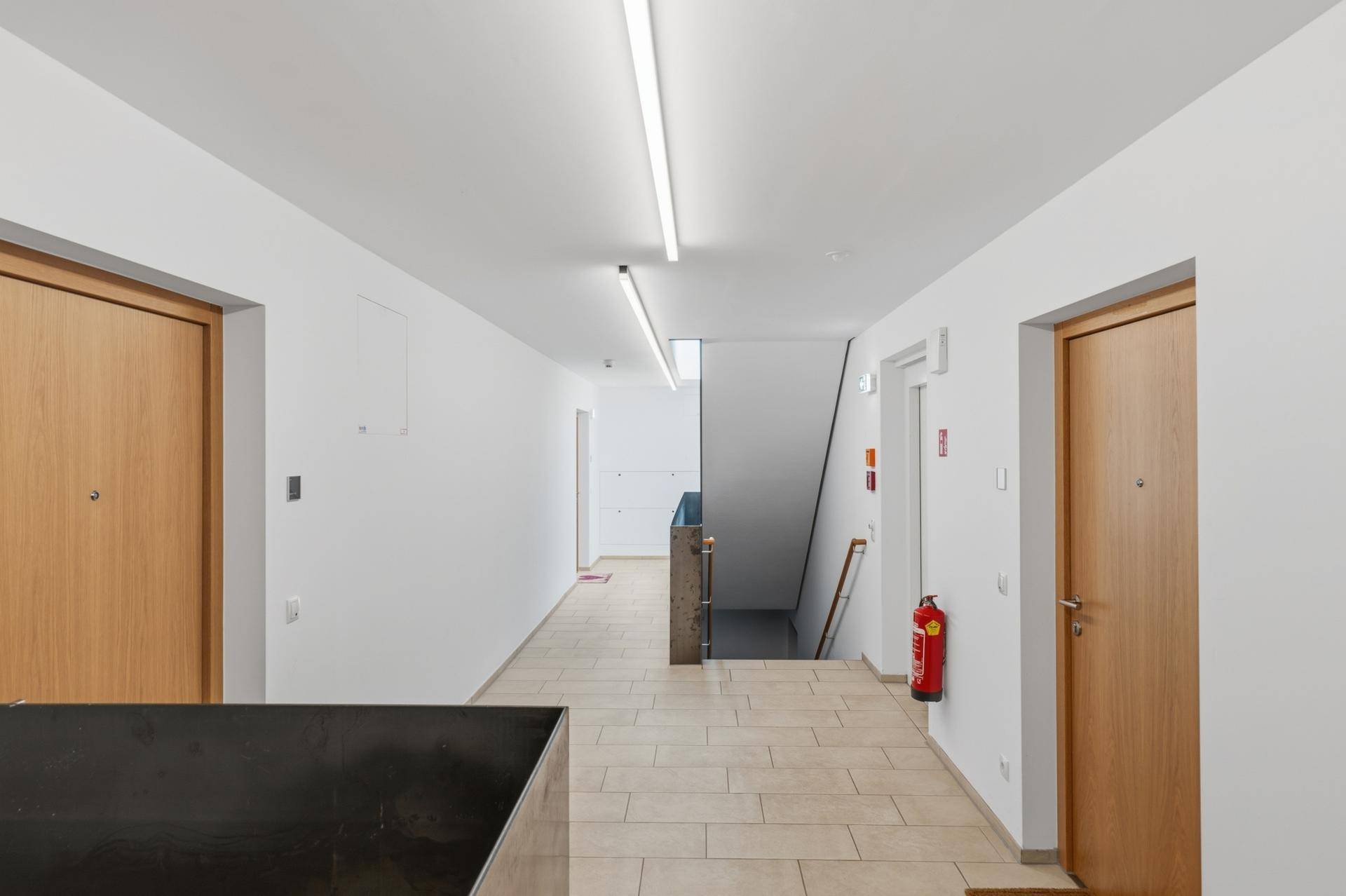 Heller Flur im Gebäude mit Zugang zu den Wohnungen und Treppenhaus.