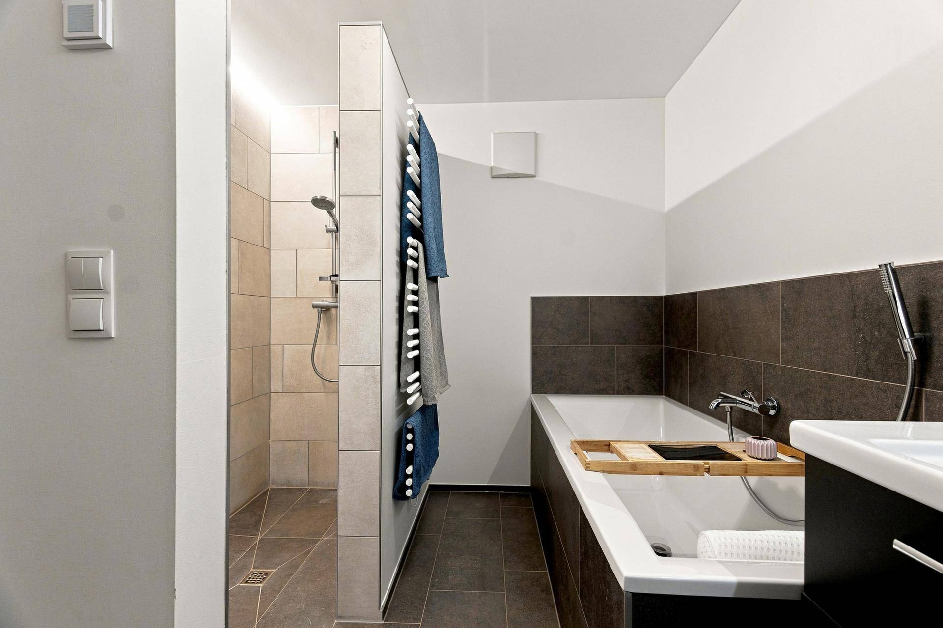 Geräumiges Badezimmer mit begehbarer Dusche, Badewanne und modernem Design.