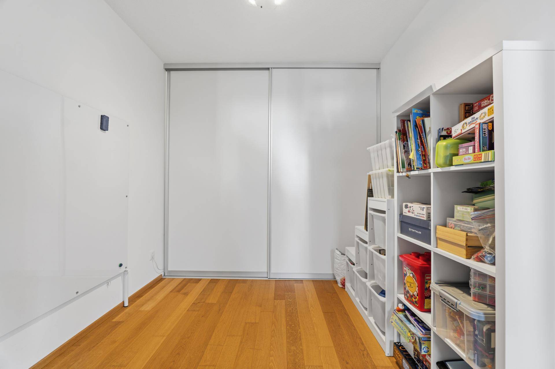 Geräumiger Abstellraum mit Schiebetürenschrank und Regalen für zusätzlichen Stauraum.
