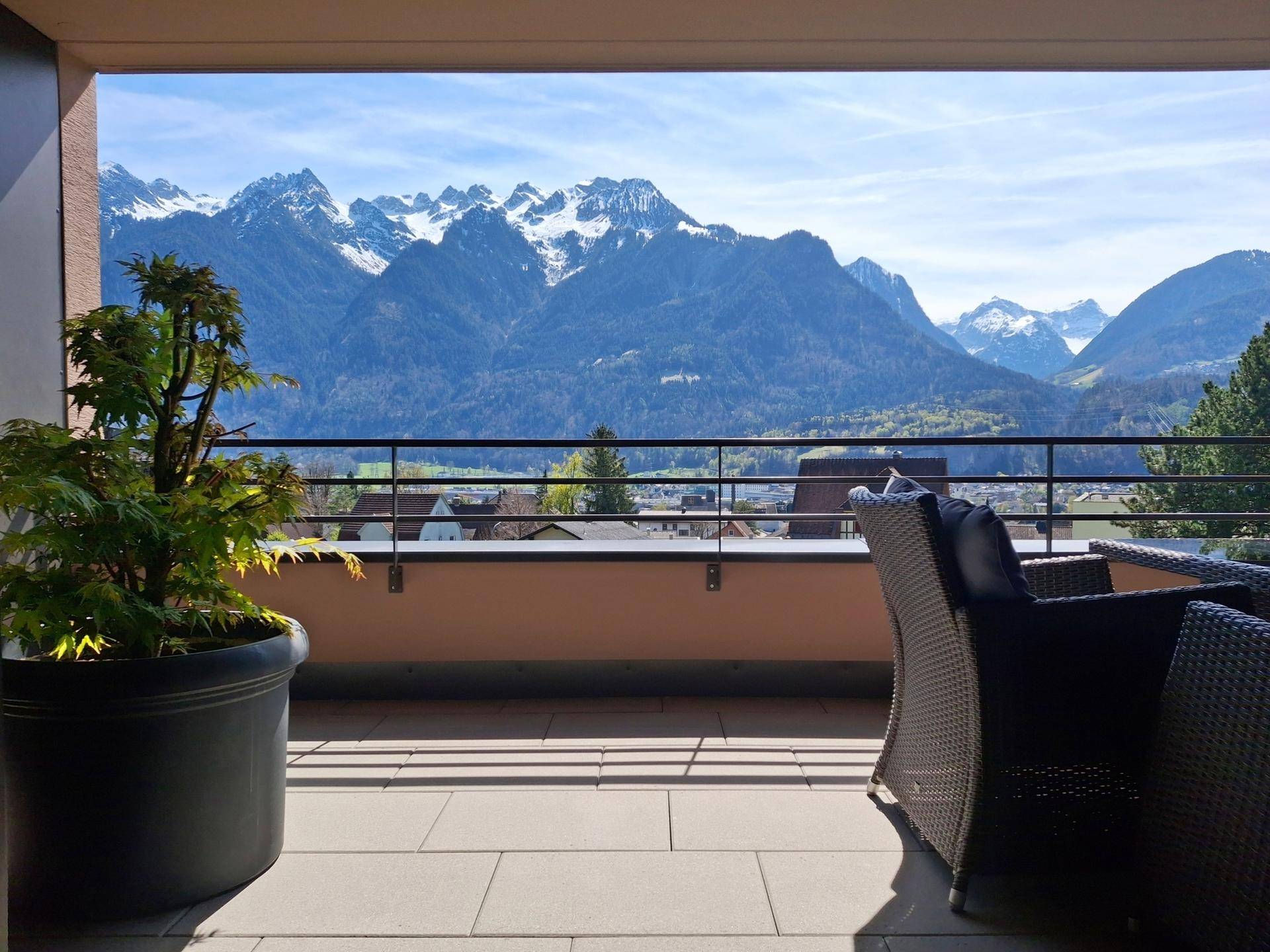 Balkon mit Pflanzen und Panoramablick auf die schneebedeckten Berge.