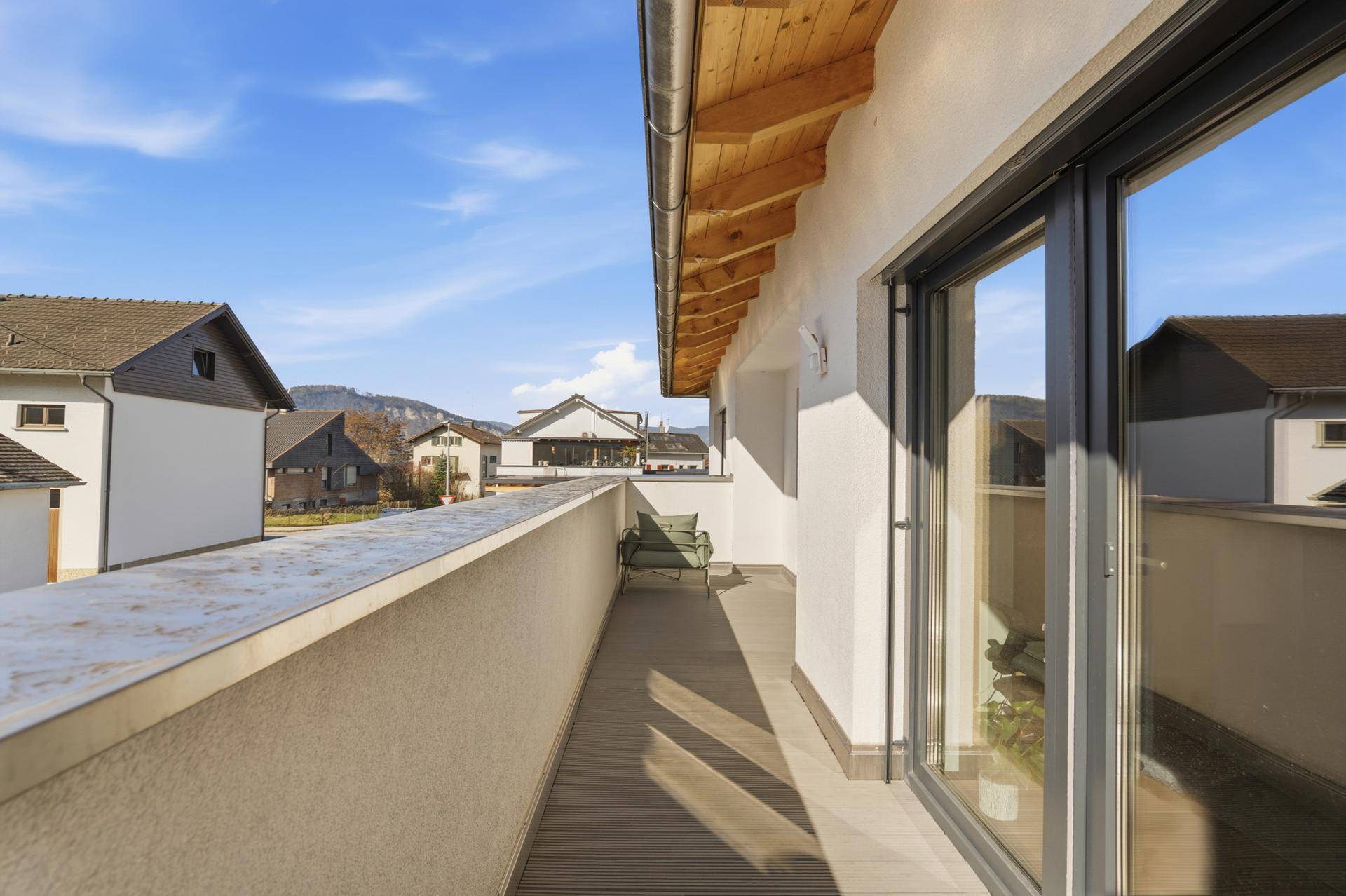 Langer Balkon mit Holzboden und Blick auf die umliegende Landschaft.