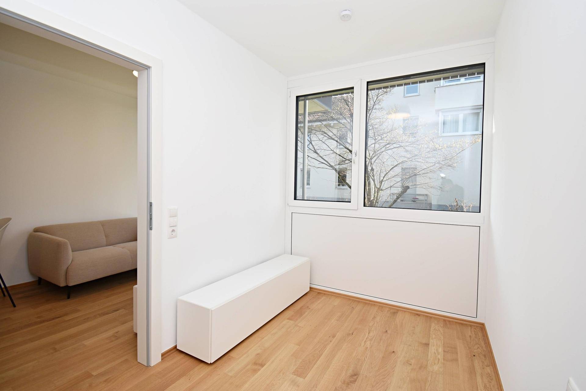 Helles Zimmer mit großem Fenster und Blick ins Grüne, ideal als Büro oder Gästezimmer nutzbar.