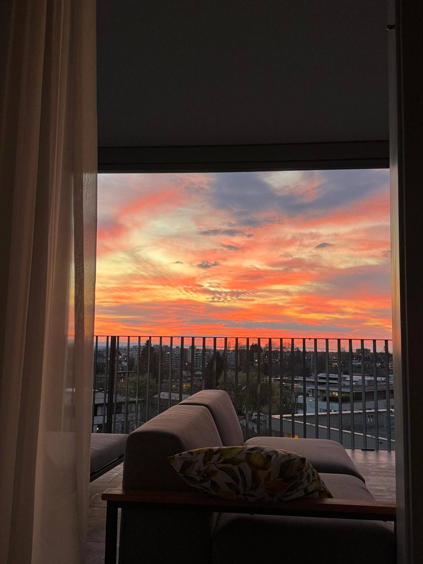 Farbenfroher Sonnenuntergang über der Stadt, von der Terrasse aus genossen.