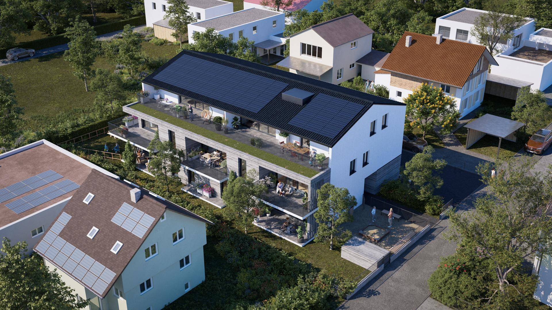 Luftaufnahme eines modernen Mehrfamilienhauses mit Balkonen, Terrassen und Photovoltaikanlage auf dem Dach.