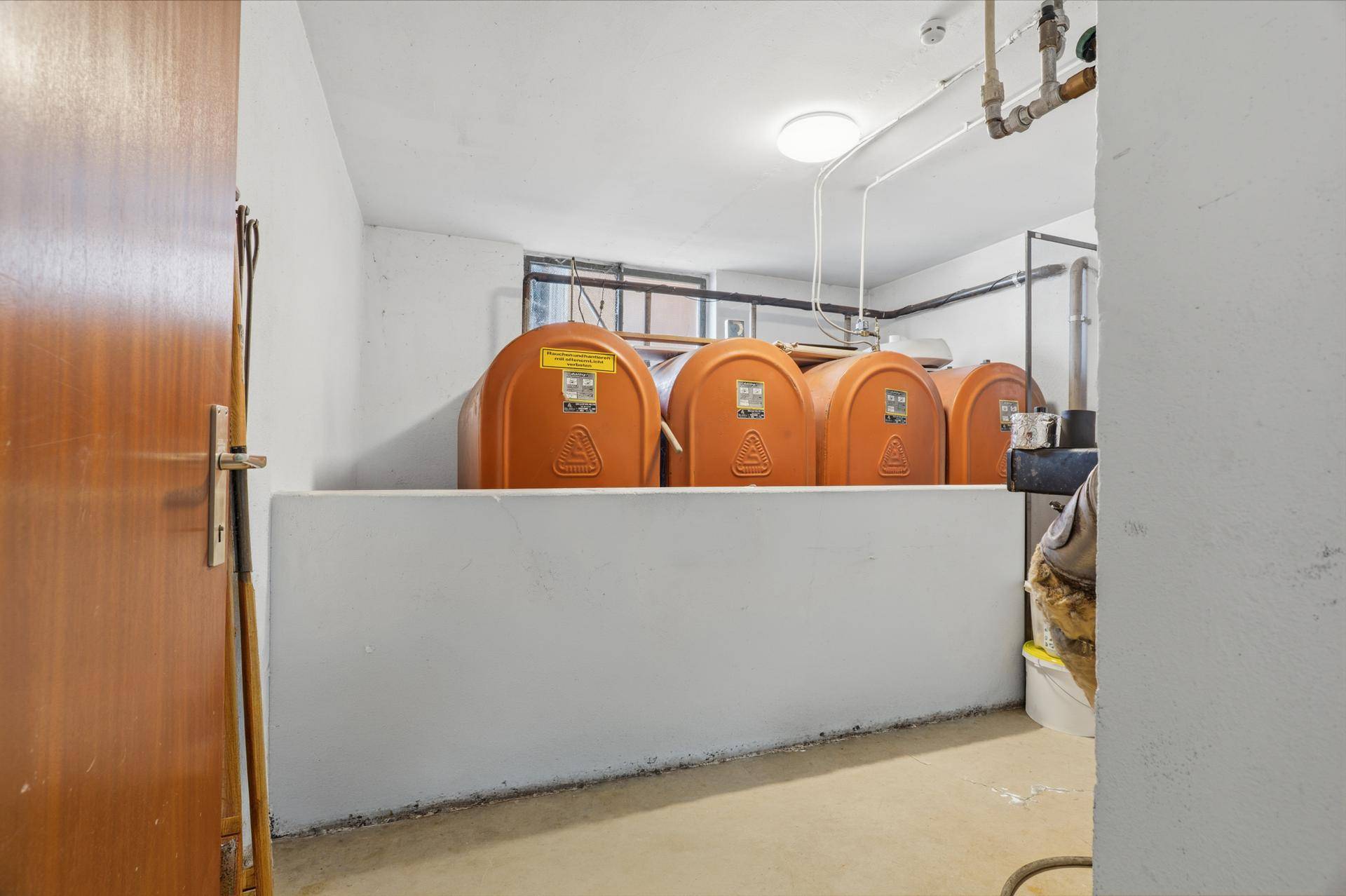 Heizraum im Keller mit Öltanks und sichtbaren Installationen.