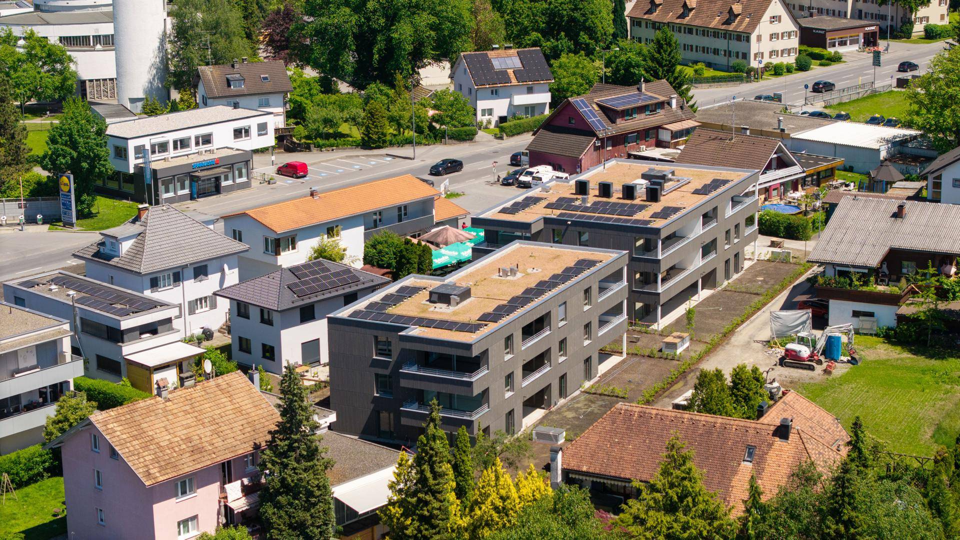 Übersicht der modernen Wohngebäude in einer städtischen Umgebung mit weiteren Häusern und Straßen.
