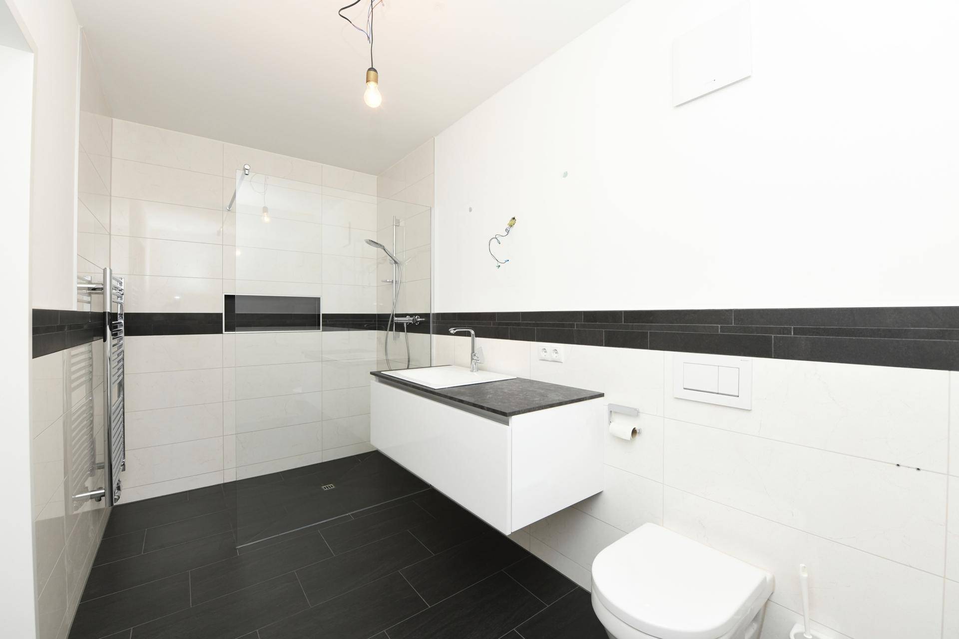 Modernes Badezimmer mit begehbarer Dusche, Wand-WC und beheiztem Handtuchhalter.
