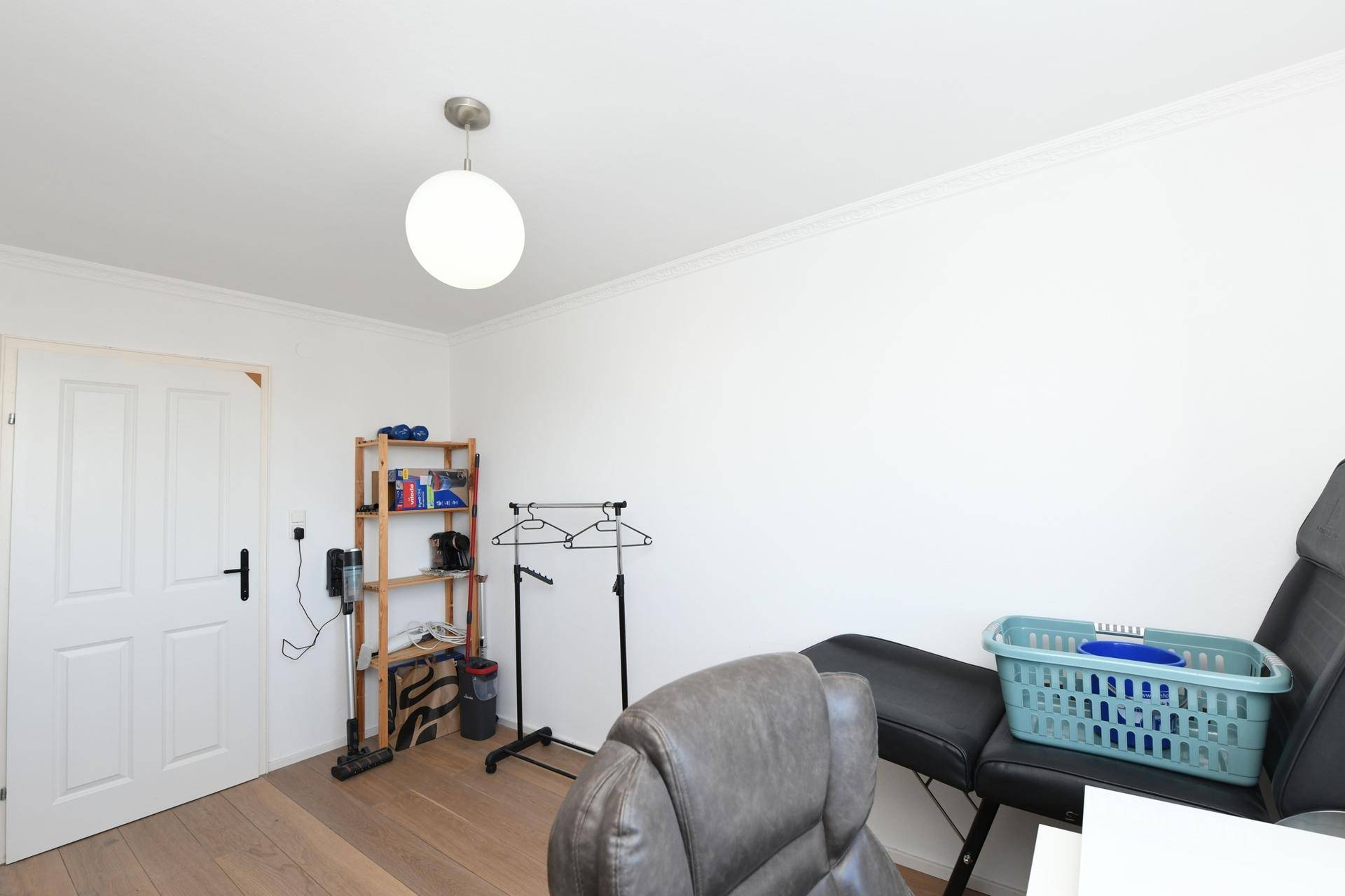 Funktional eingerichtetes Zimmer mit Holzboden und Stauraum, vielseitig nutzbar.