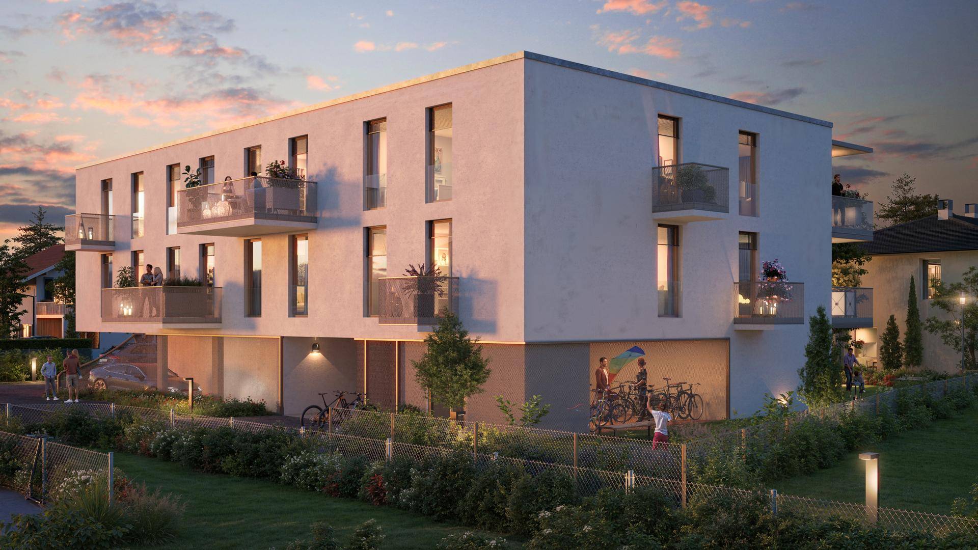 Ansicht der modernen Wohnanlage mit Balkonen und Tiefgaragenzufahrt, eingebettet in eine grüne Umgebung.