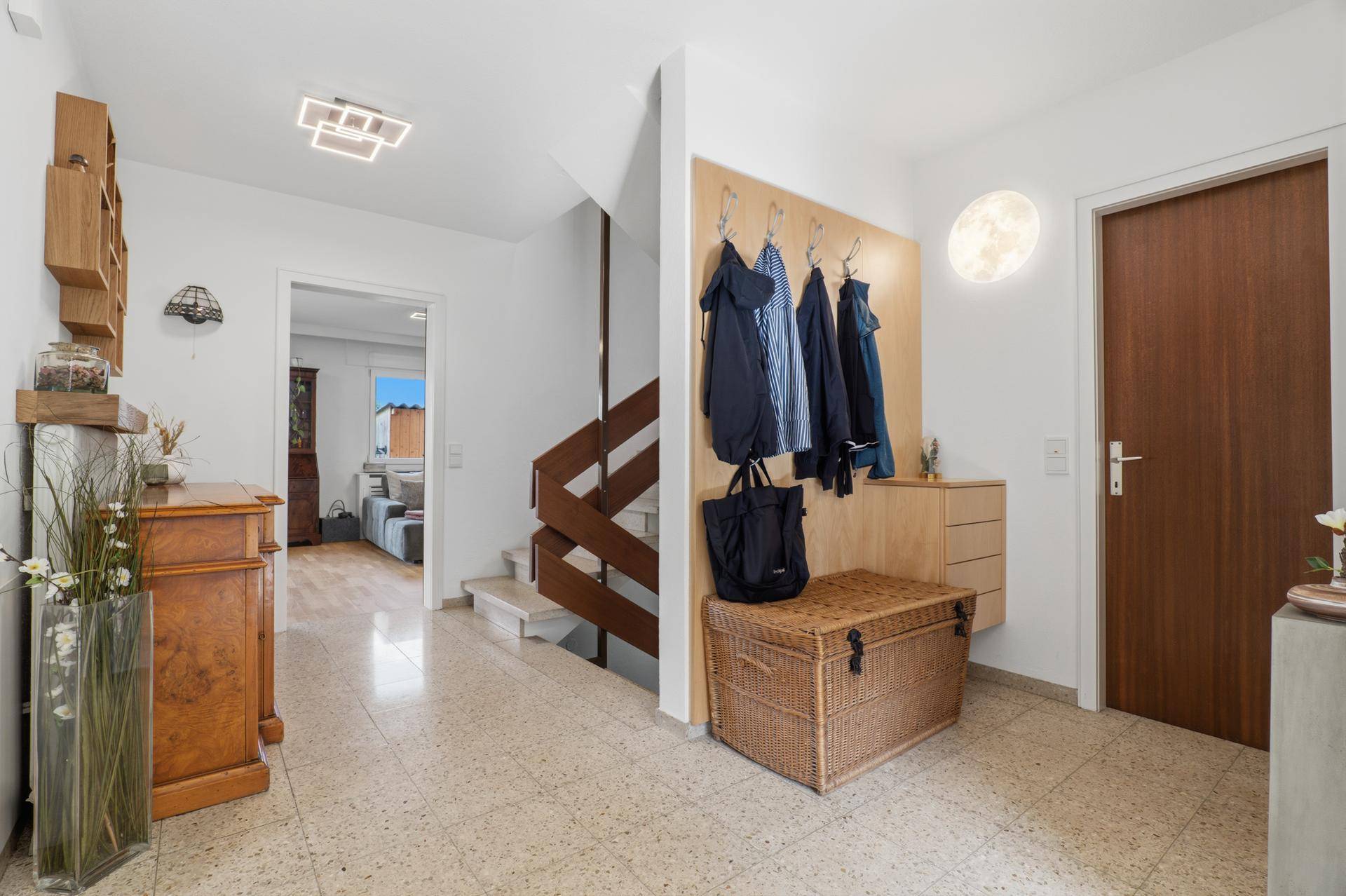 Eingangsbereich mit Garderobe, Terrazzoboden und Zugang zu den oberen Etagen.