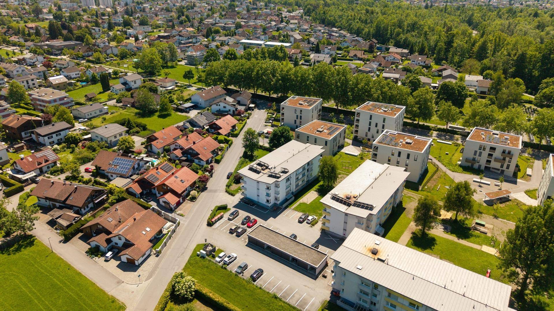Vogelperspektive auf eine Wohnsiedlung mit Einfamilienhäusern und Mehrfamilienhäusern.