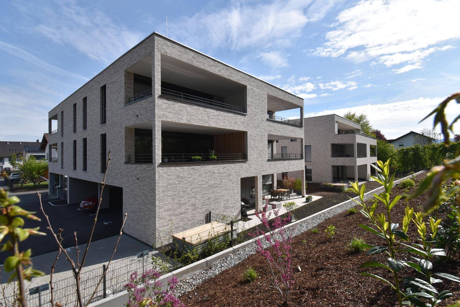 Moderne Wohnanlage mit ansprechender Architektur, Balkonen und gepflegter Außenanlage.