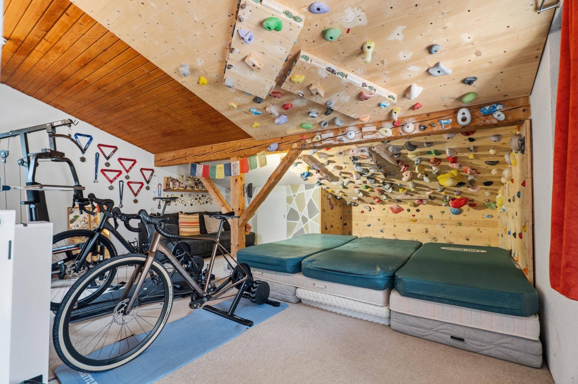 Einzigartiger Raum im Dachgeschoss mit Kletterwand und Sportgeräten.