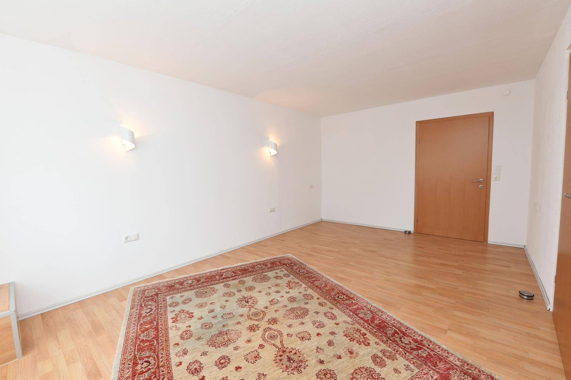 Helles Schlafzimmer mit Laminatboden und schlichter Einrichtung, ideal zum Entspannen.