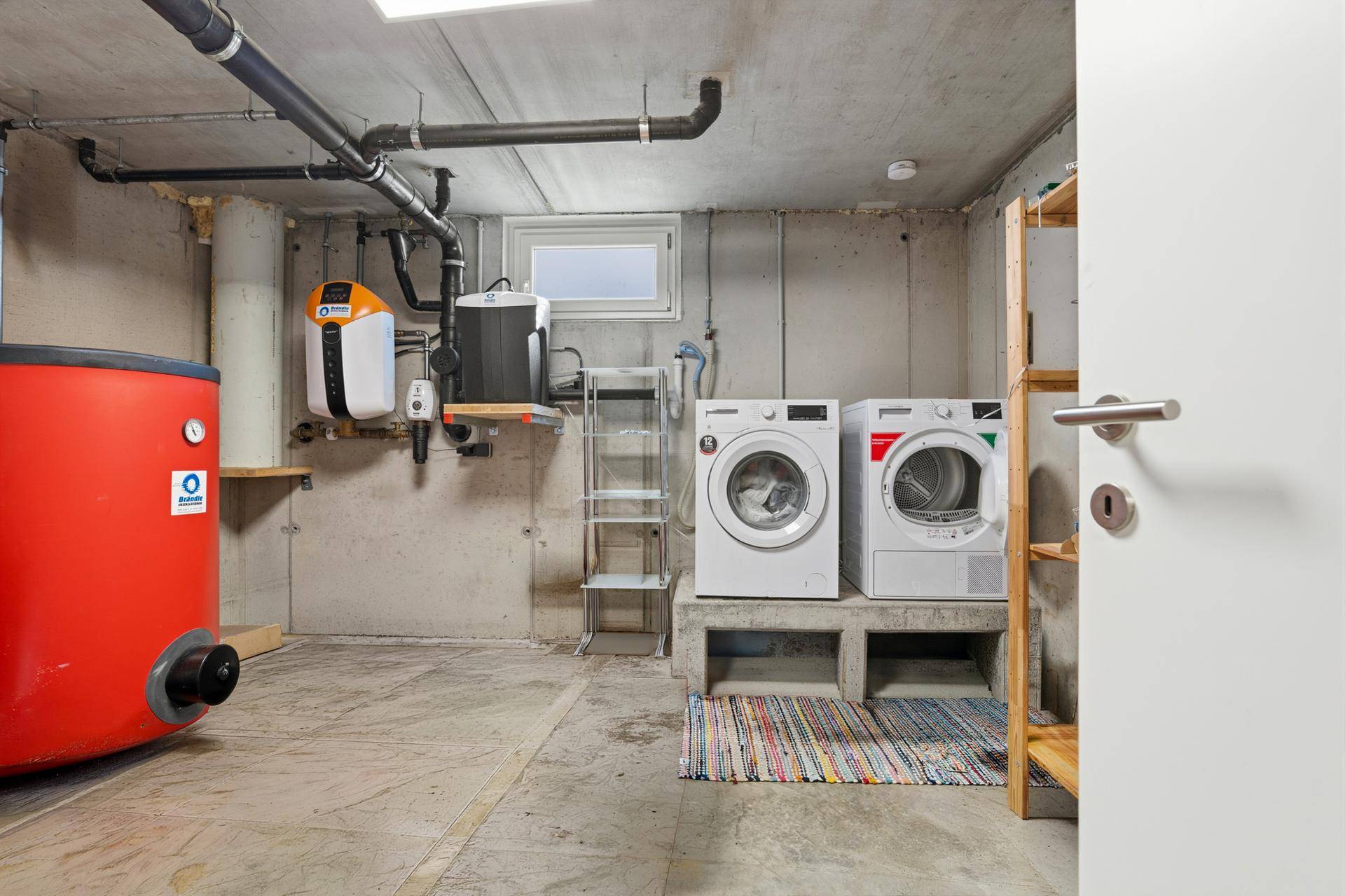 Waschküche im Keller mit Waschmaschine, Trockner und Heizungsanlage.