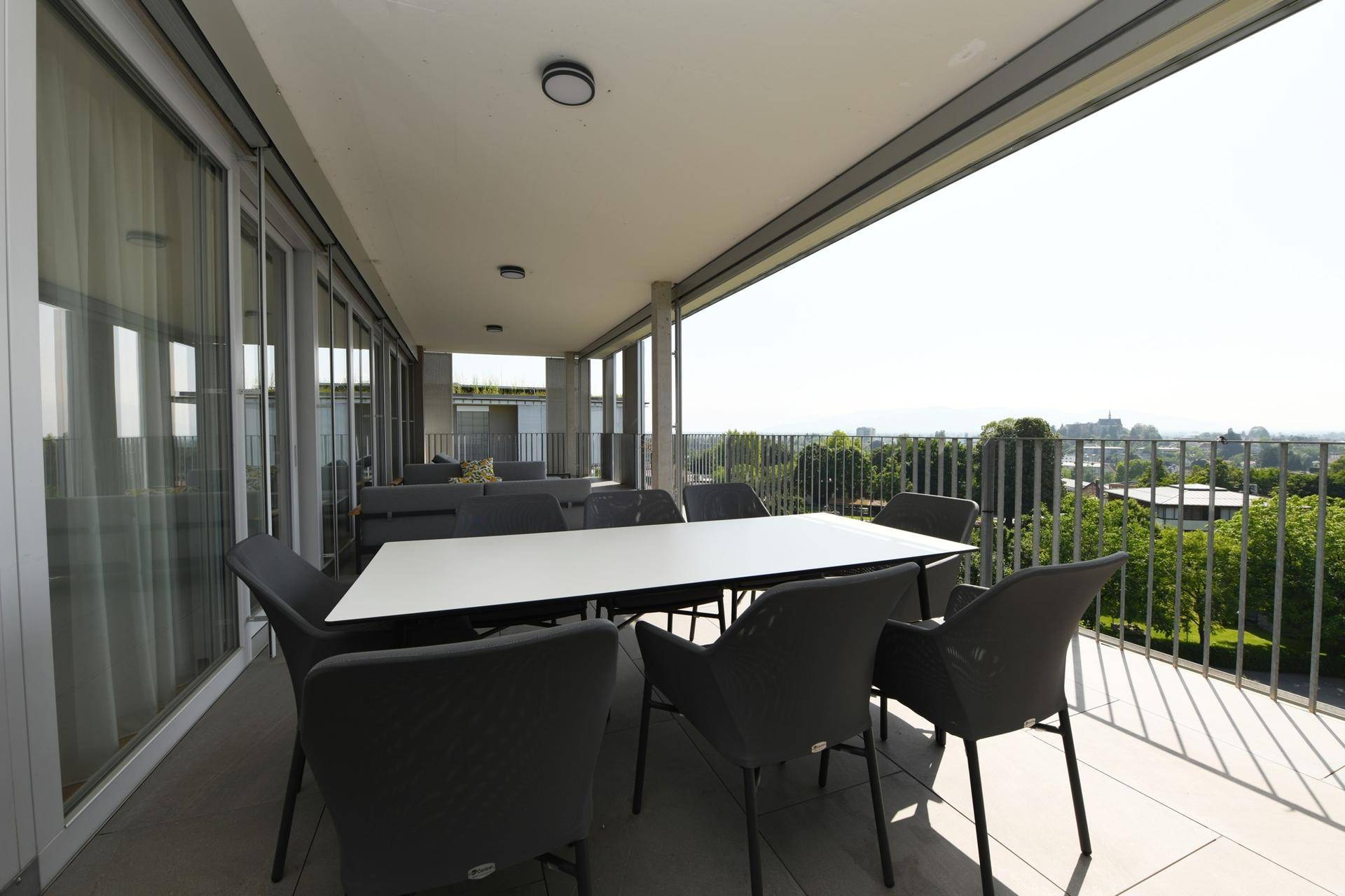 Essbereich auf der Terrasse mit großem Tisch und Stühlen, ideal für Mahlzeiten im Freien.