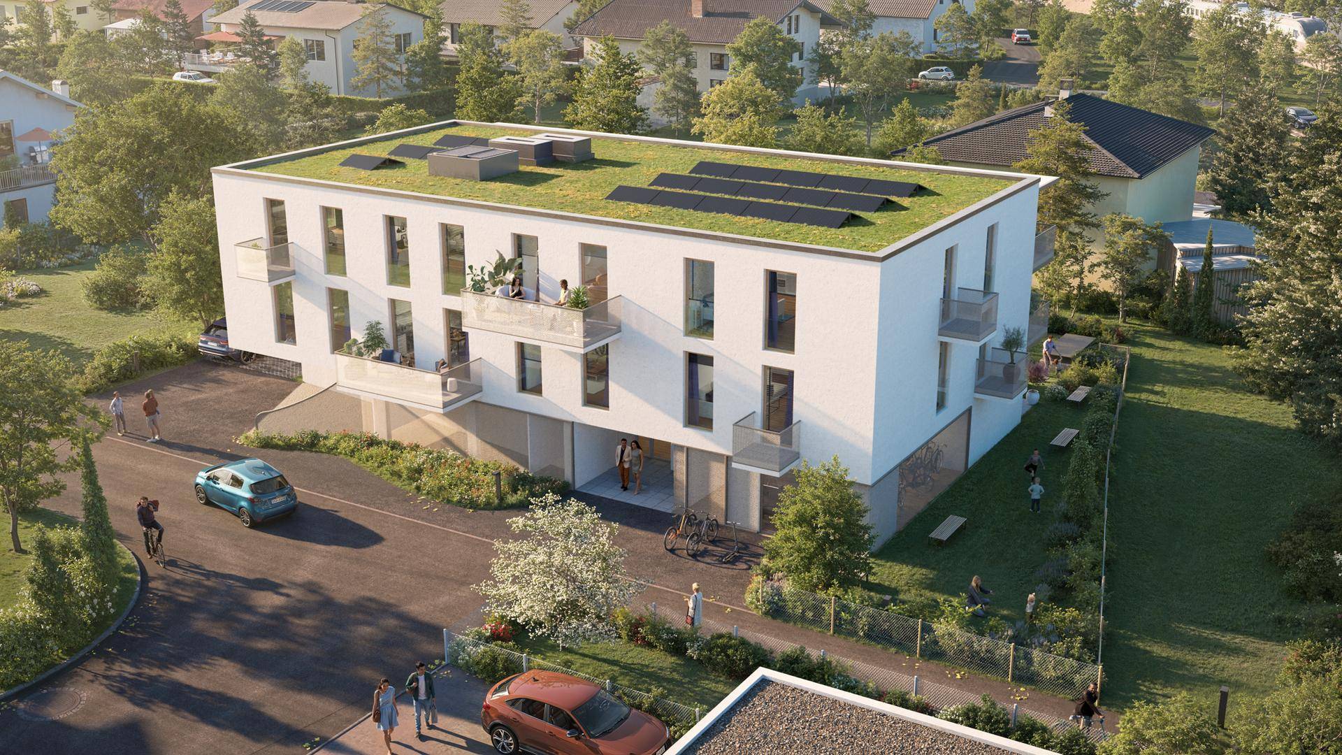 Luftaufnahme der modernen Wohnanlage mit Gründach und Photovoltaikanlage, umgeben von Wohnbebauung.