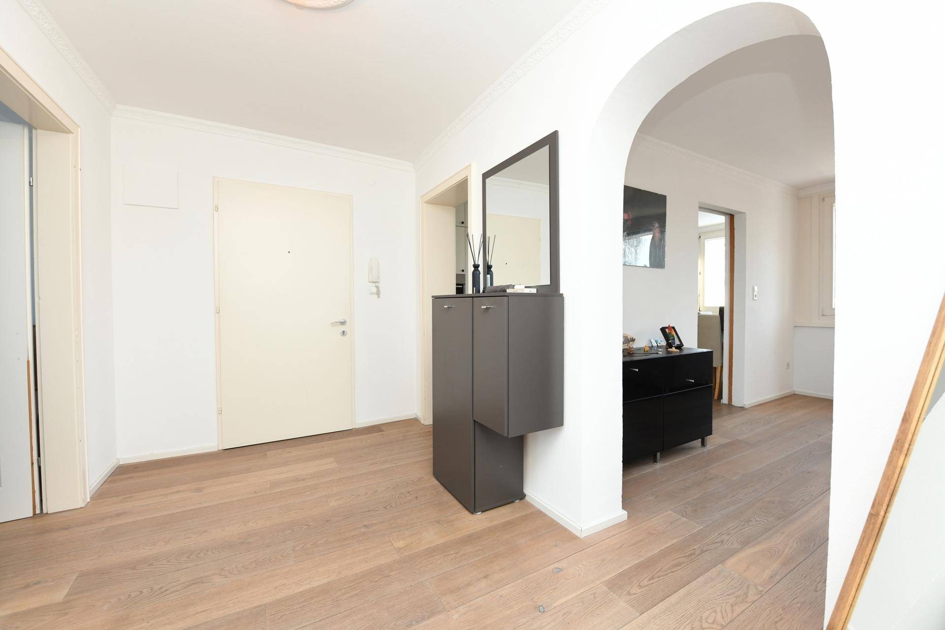 Heller Eingangsbereich mit Holzboden und Garderobe, einladend gestaltet.