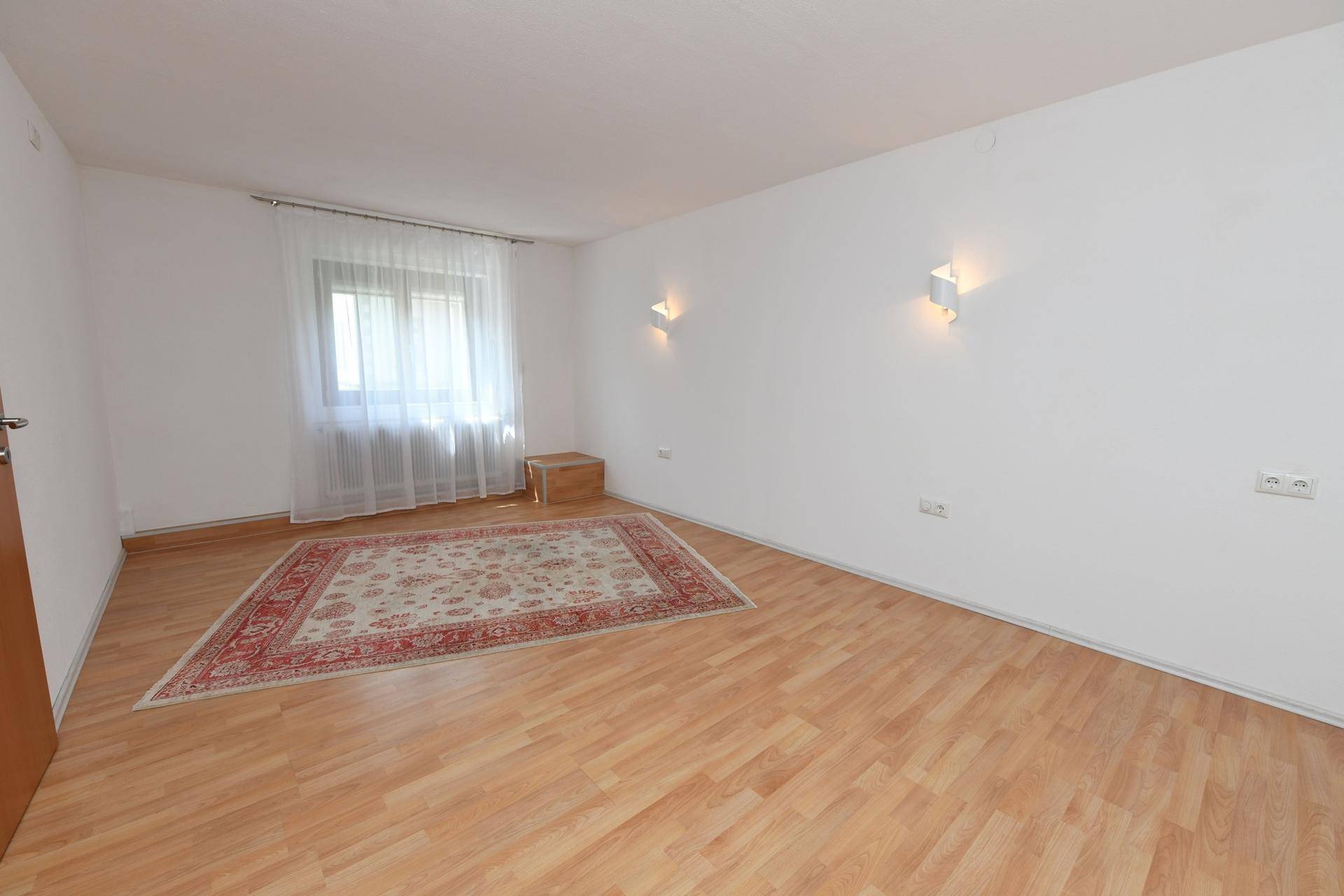 Schlafzimmer mit Laminatboden, großem Fenster und heller Wandgestaltung für angenehmes Wohnen.