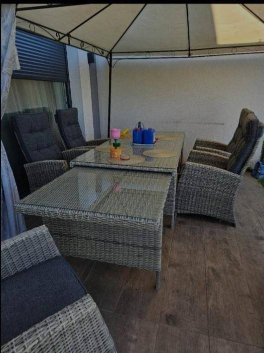 Detailansicht der Rattan-Sitzgruppe unter dem Pavillon auf der Terrasse.