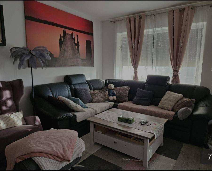 Gemütliches Wohnzimmer mit großem Ecksofa, Couchtisch und dekorativem Wandbild.