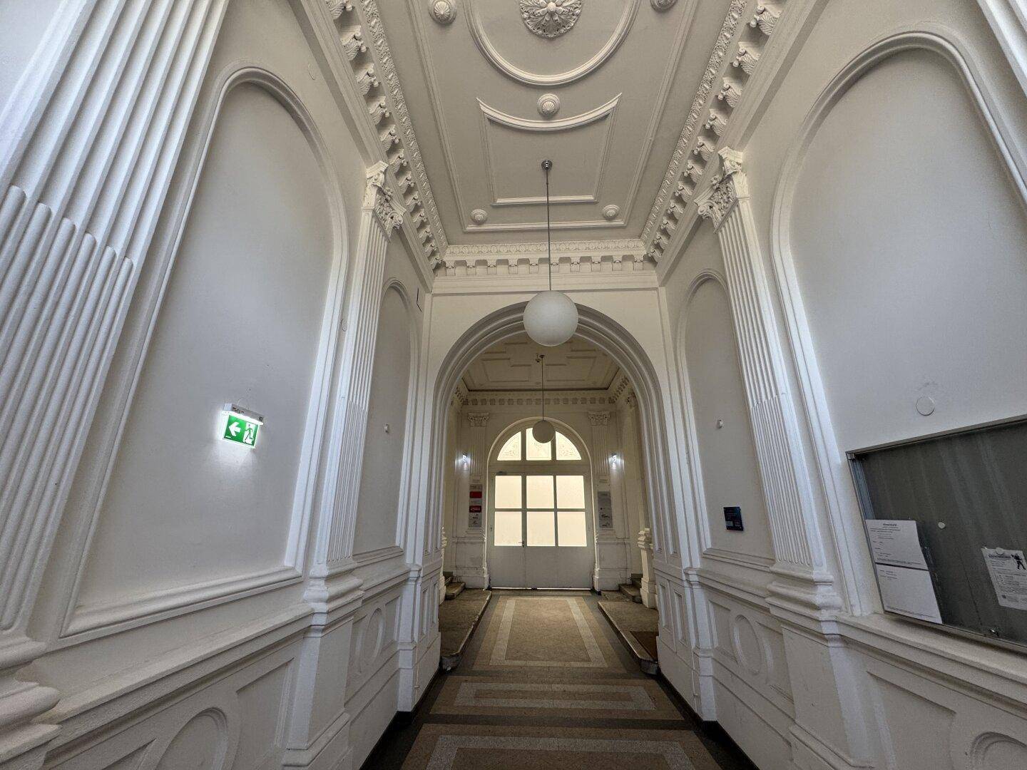 Prunkvoller Eingangsbereich mit reich verzierten Stuckdecken, eleganten Bögen und gemustertem Boden.