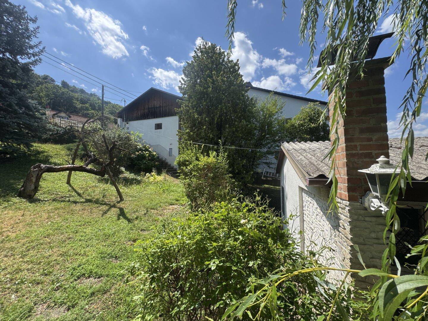 Gartenansicht mit Blick auf das Haupthaus und einen traditionellen Ziegelkamin.