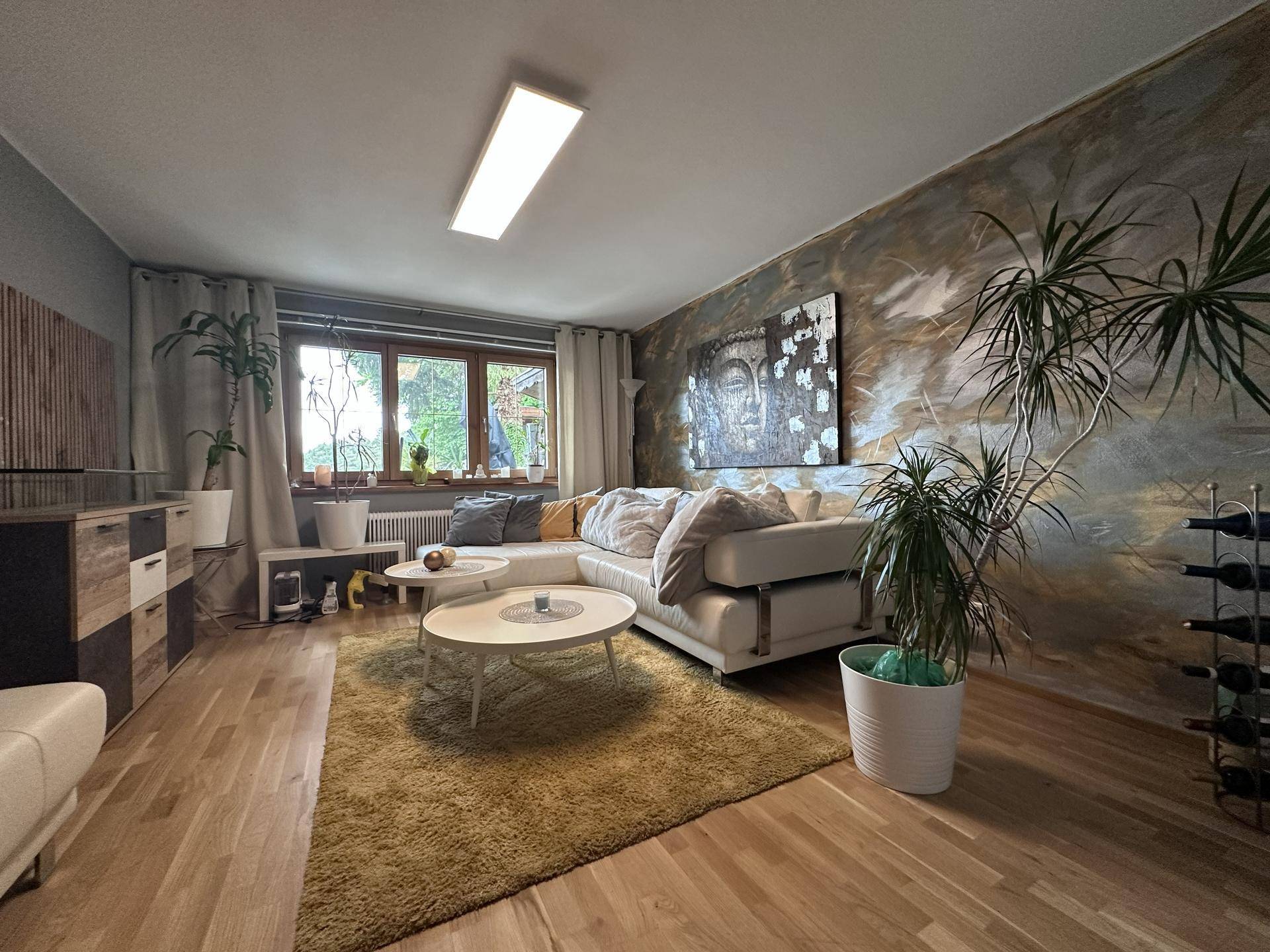 Helles Wohnzimmer mit modernem Design, Holzboden und dekorativer Wandgestaltung.