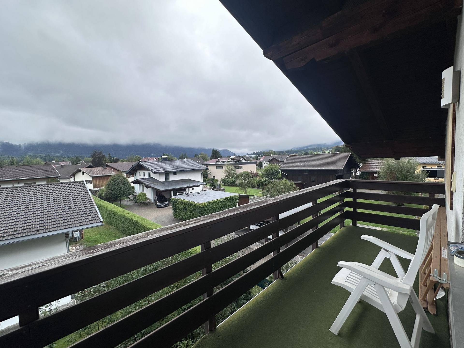 Gemütlicher Balkon mit Kunstrasen und weitem Blick über die Dächer und Berge.