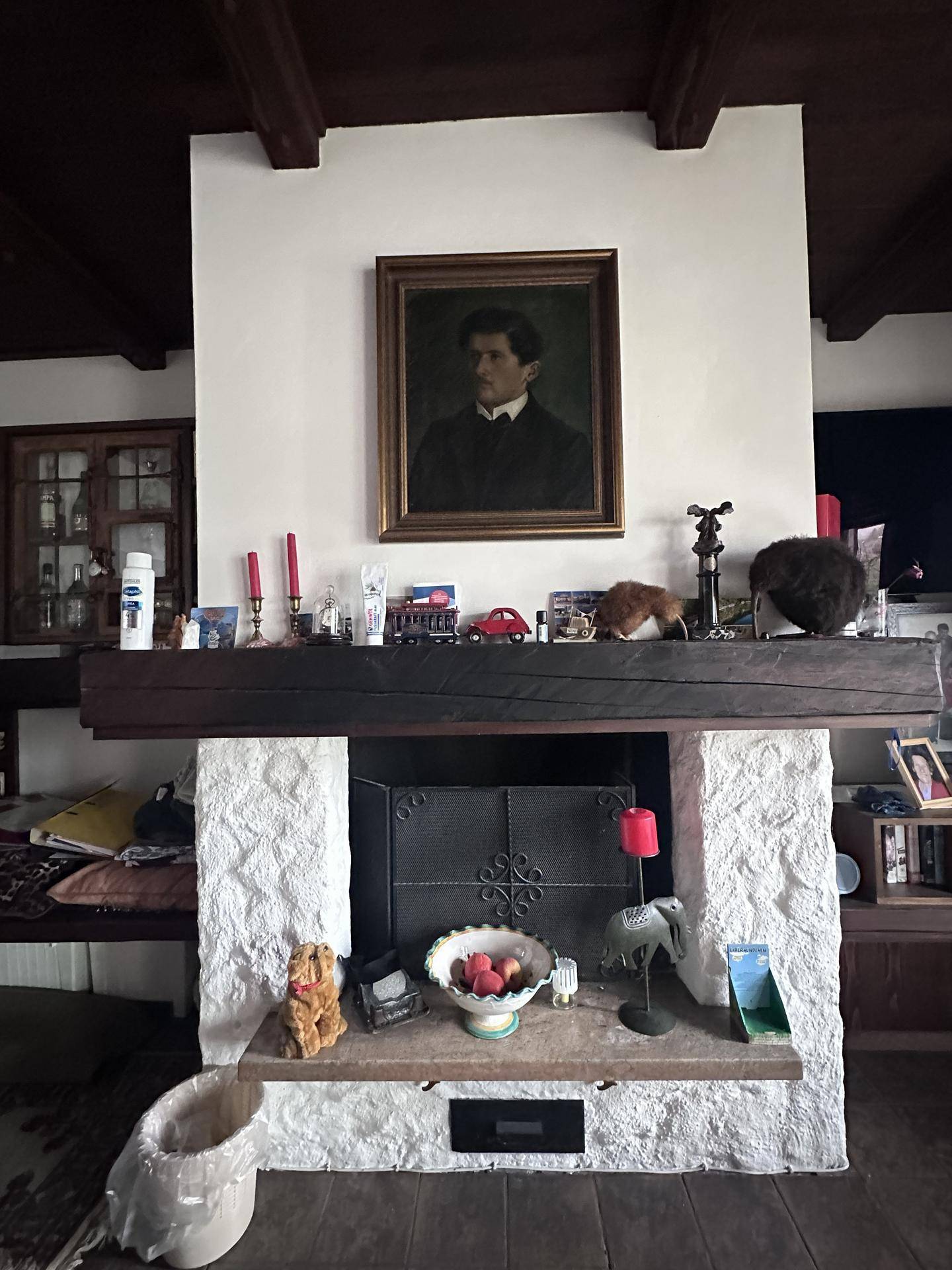 Detailansicht eines Kamins mit weißem Stein und Holzmantel im Wohnzimmer.