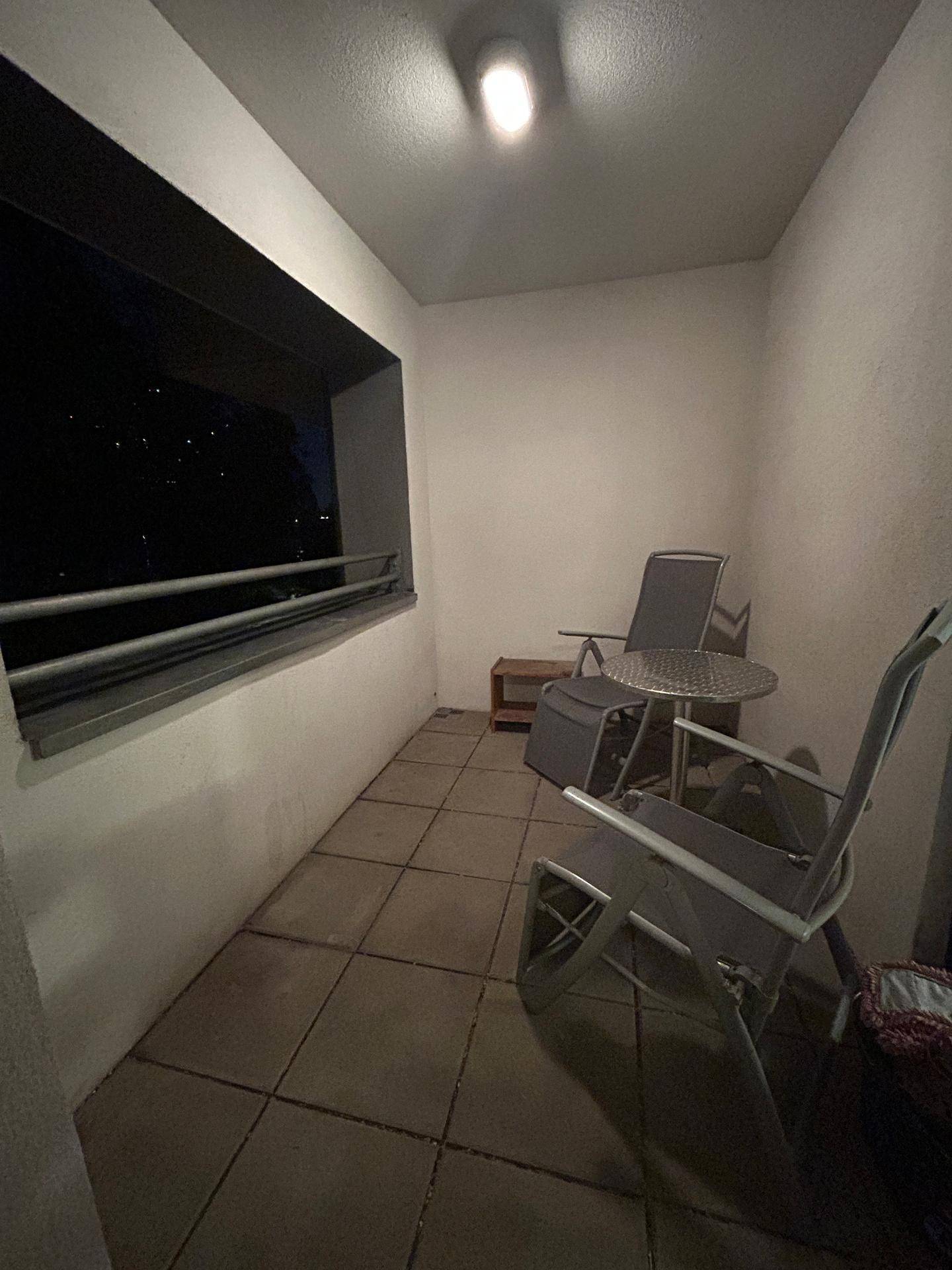 Balkon mit Fliesenboden und Gartenmöbeln, ideal für entspannte Abende im Freien.
