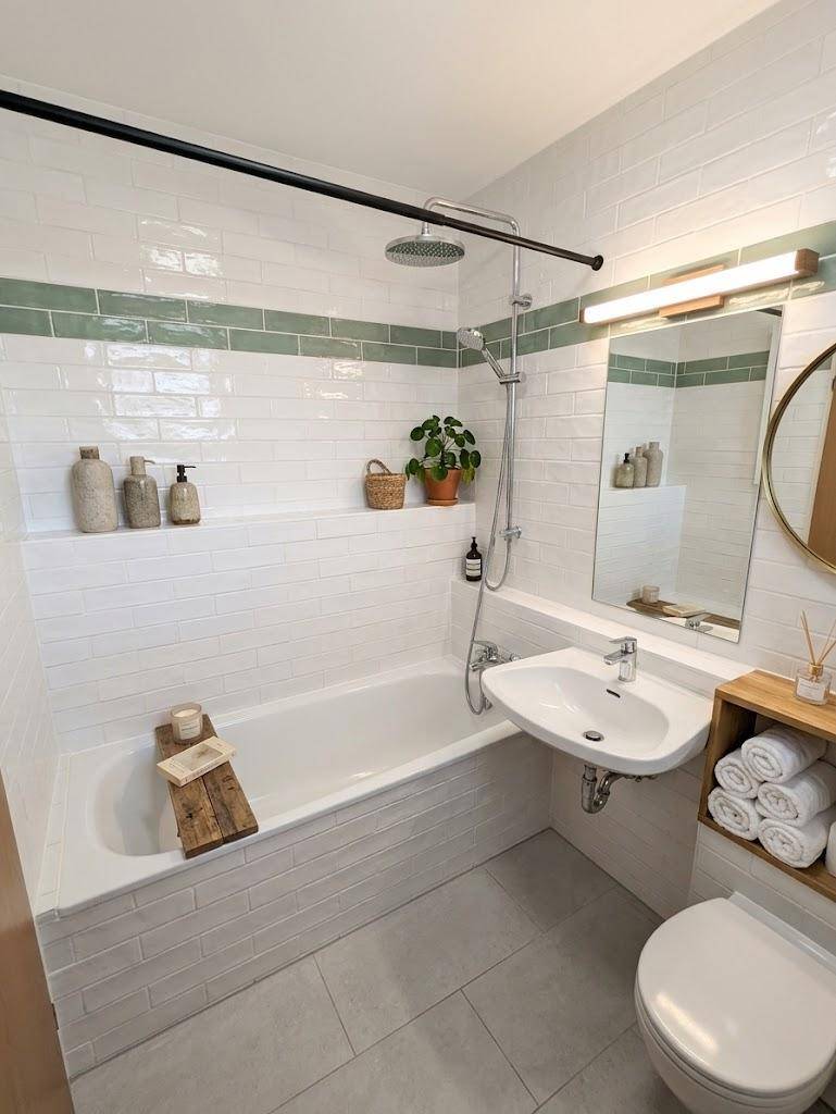 Modernes Badezimmer mit Badewanne, Regendusche und grünen Akzentfliesen.