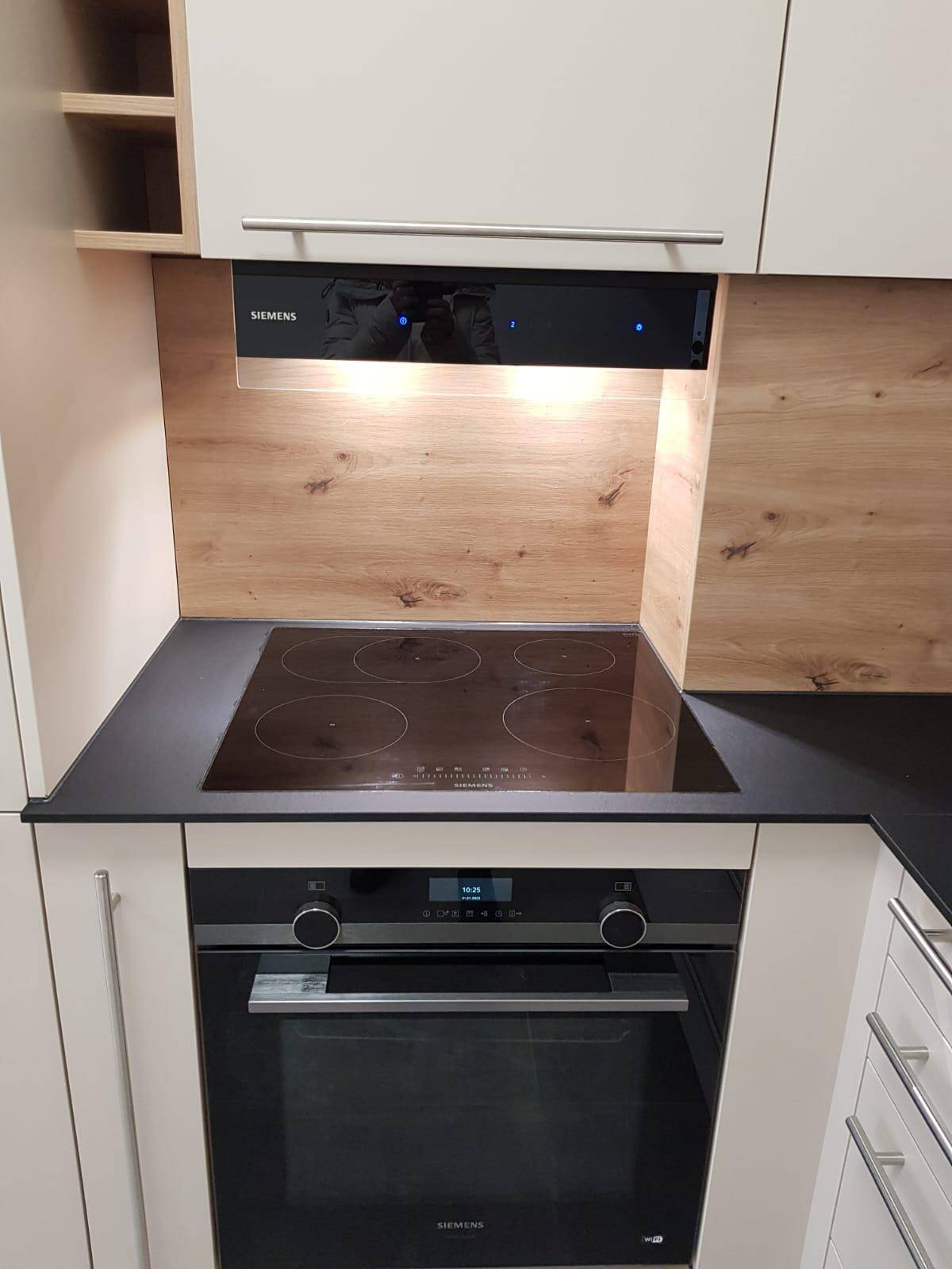 Modernes Induktionskochfeld und Backofen von Siemens mit Dunstabzugshaube in der Küche.