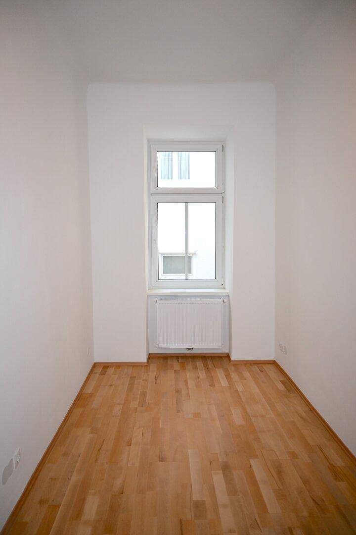 Kleiner, heller Raum mit einem Fenster, Parkettboden und Heizkörper, vielseitig nutzbar.