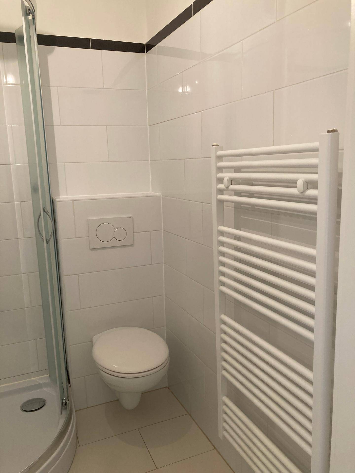 Helles Badezimmer mit wandhängendem WC und praktischem Handtuchheizkörper.